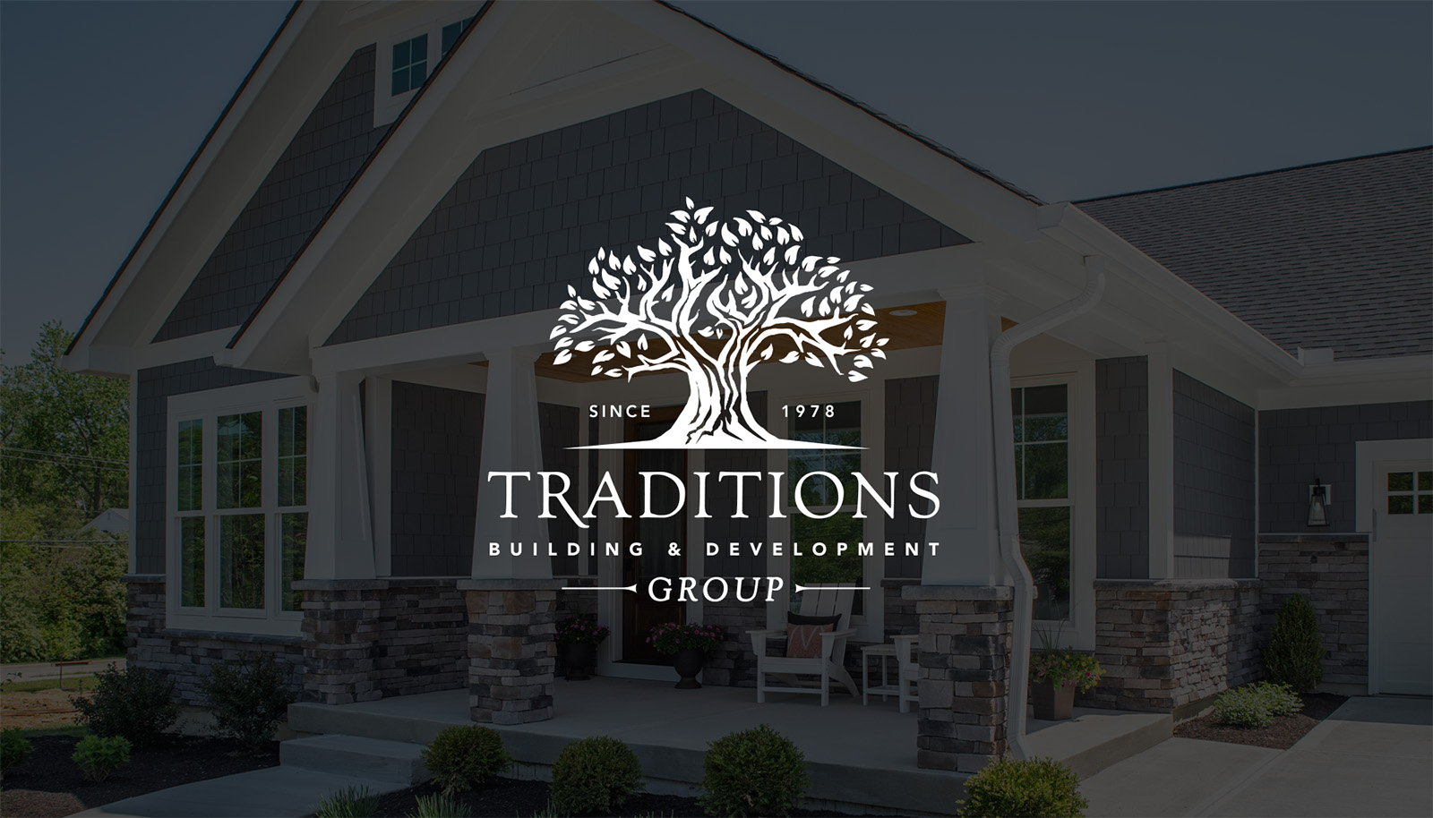 Traditions logo in white over an image of a house